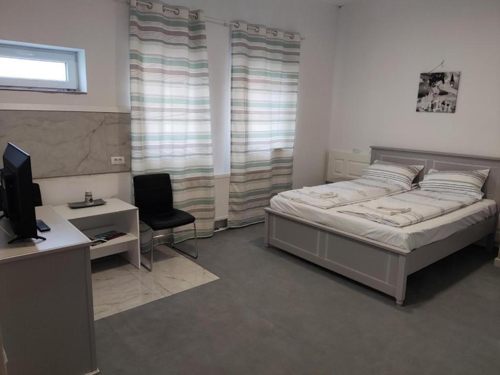 胡内多阿拉Cazare SPORT CONFORT的一间卧室配有一张床、一张桌子和一台电脑