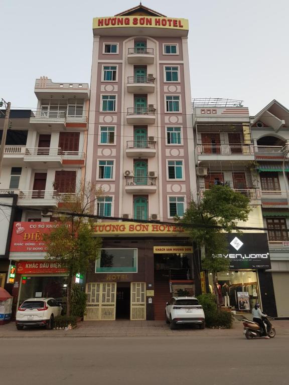 Bắc GiangKhách Sạn Hương Sơn的一座大型建筑,前面有汽车停放