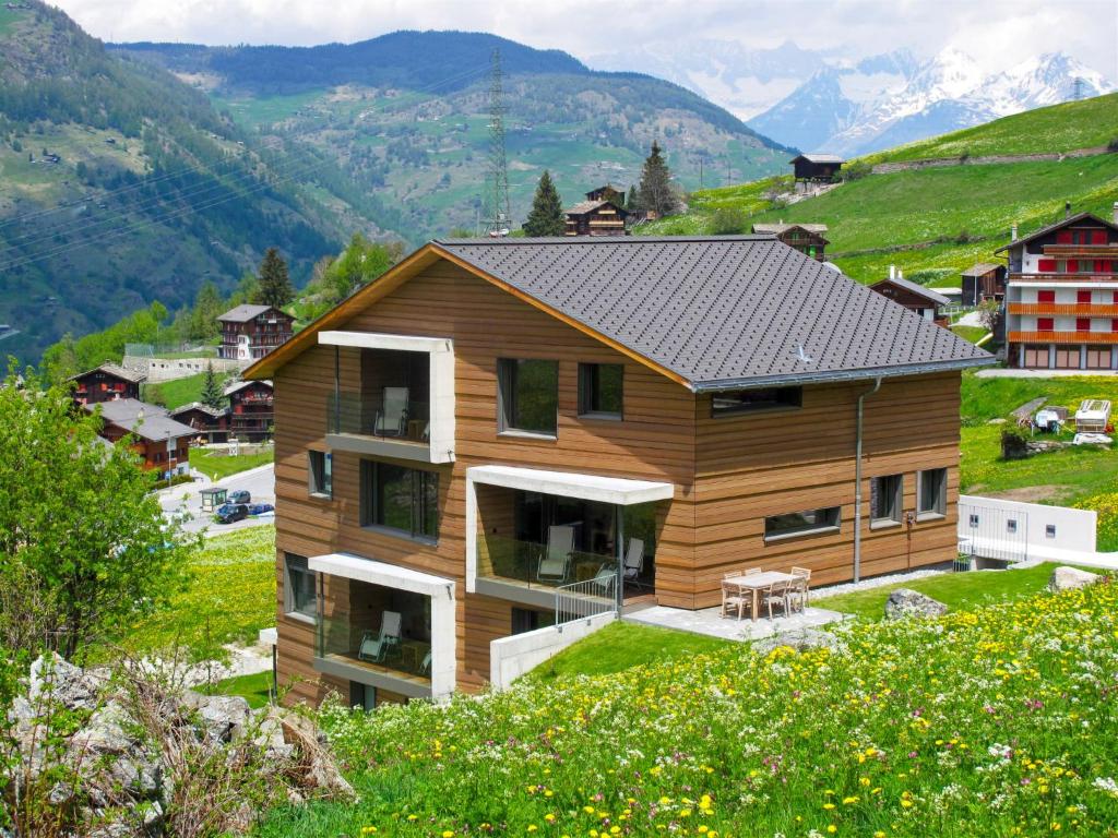 格雷兴Apartment Sera Lodge- Wohnung Brunegghorn by Interhome的山丘上以山为背景的房子
