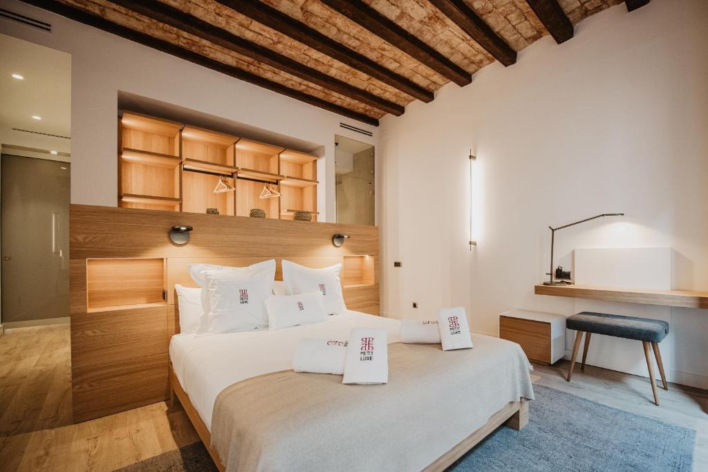 特拉萨Petit Luxe St. Pere的一间卧室配有一张大床,上面有两张价格标志