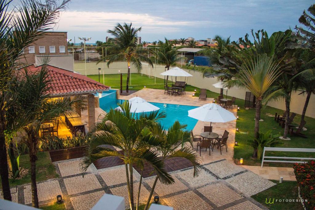 阿奎拉兹Pousada Tropical Ilhas的享有带桌子和遮阳伞的游泳池的顶部景致