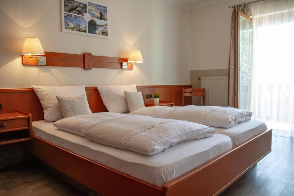 AltmühldorfHotel Bastei的一张配有白色床单和枕头的大床