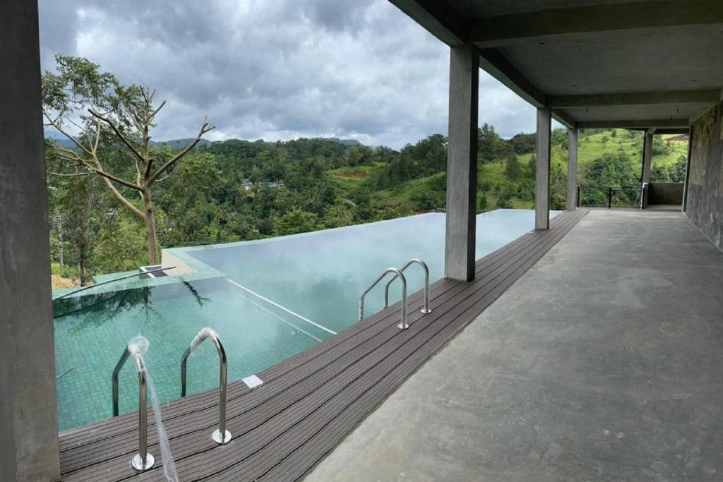 加姆波勒Riverbank Resort Gampola的观景木甲板上的游泳池