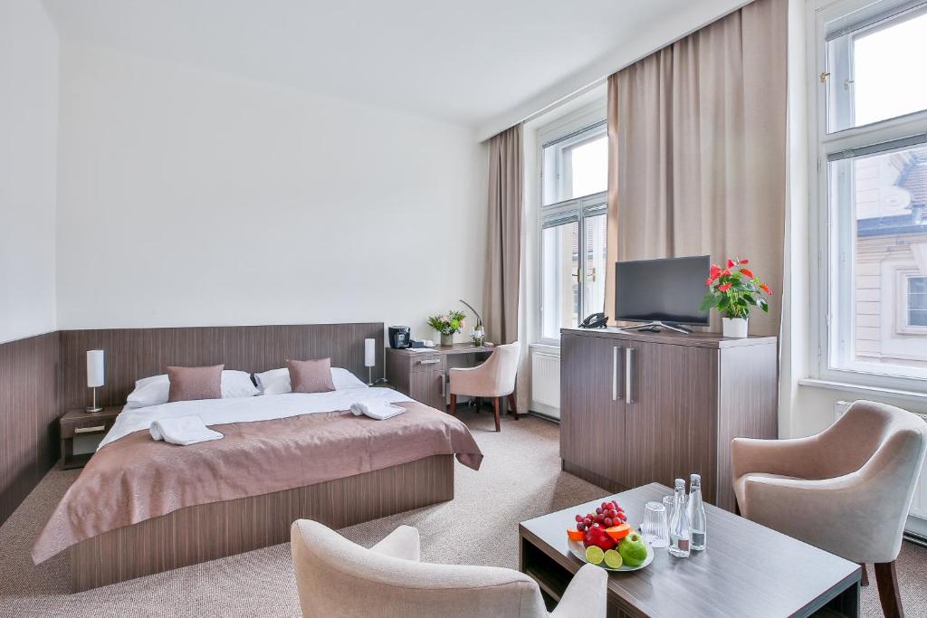 布拉格Apartments Embassy by LH的一间卧室配有一张床、一张书桌和一台电视。