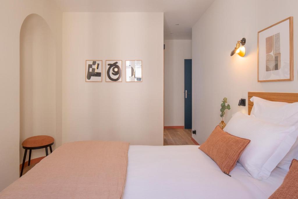 巴黎Tinah Paris, Aboukir的一间卧室配有带白色床单和枕头的床。
