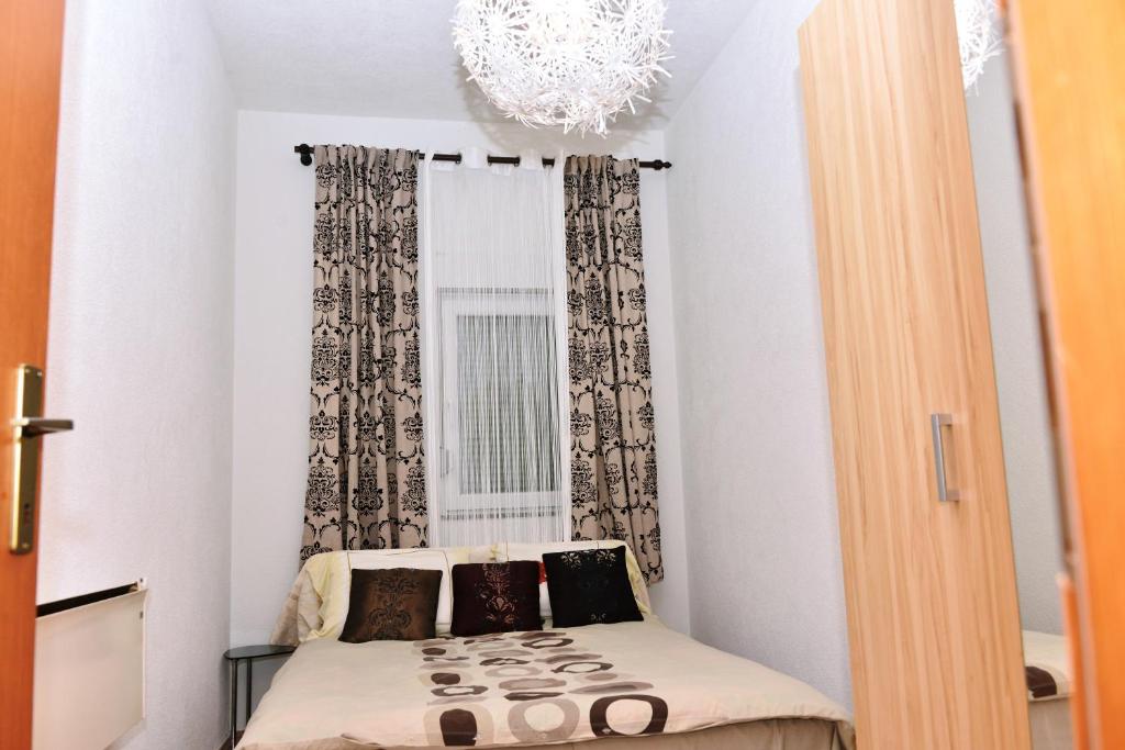 巴尼亚卢卡Apartman centar blizina Kastela i Splava的一个小房间,窗户前设有一张床