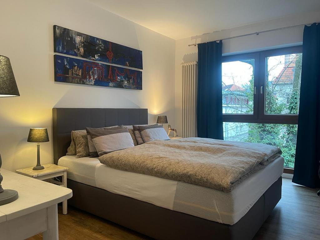柏林COSY PANKOW HOMES - Studios mit TV Stick的一间卧室设有一张大床和一个窗户。