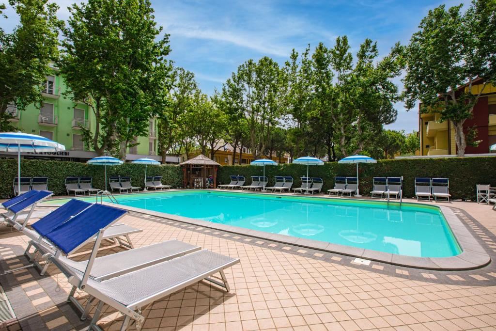 切塞纳蒂科Hotel Stacchini的一个带躺椅和遮阳伞的游泳池