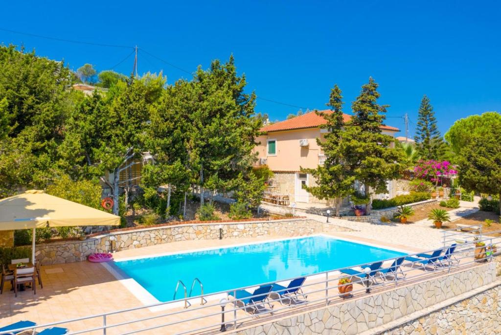 Porto OziasDolphin House的度假村内的游泳池,配有椅子和遮阳伞