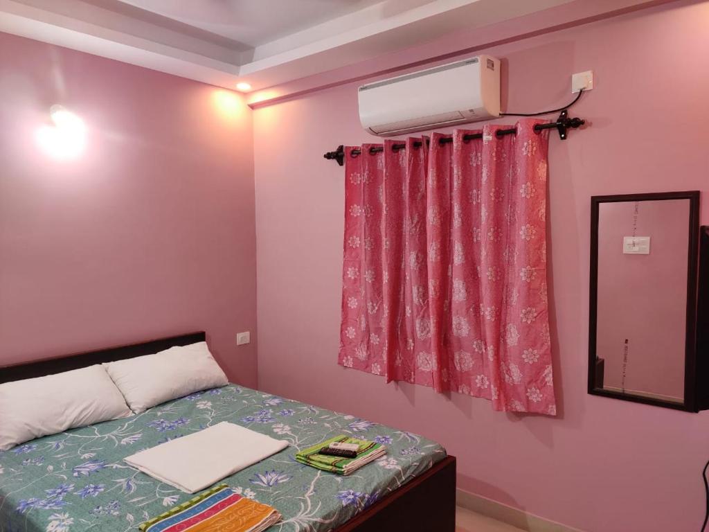 卡兰古特INDRAYANI GUEST HOUSE的一间卧室配有一张床,窗户配有空调