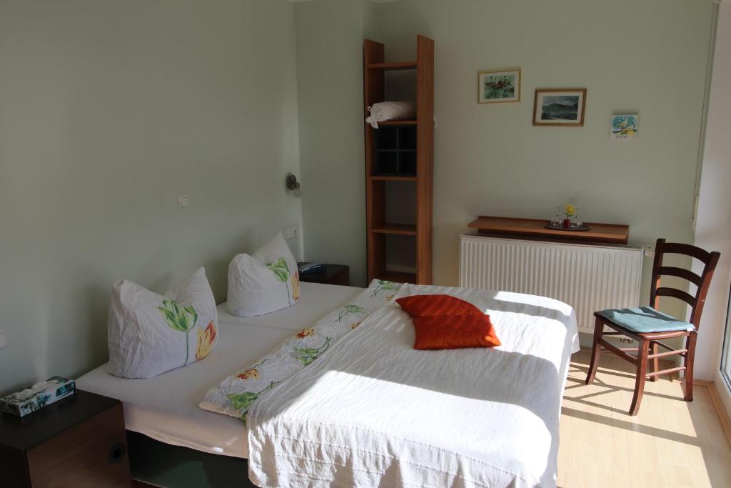 莱茵河畔洛尔希罗斯勒酒庄酒店的卧室配有1张床、1张桌子和1把椅子