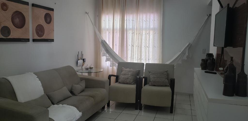 纳塔尔Confortável apartamento próximo à Ponta Negra的客厅配有沙发和两把椅子