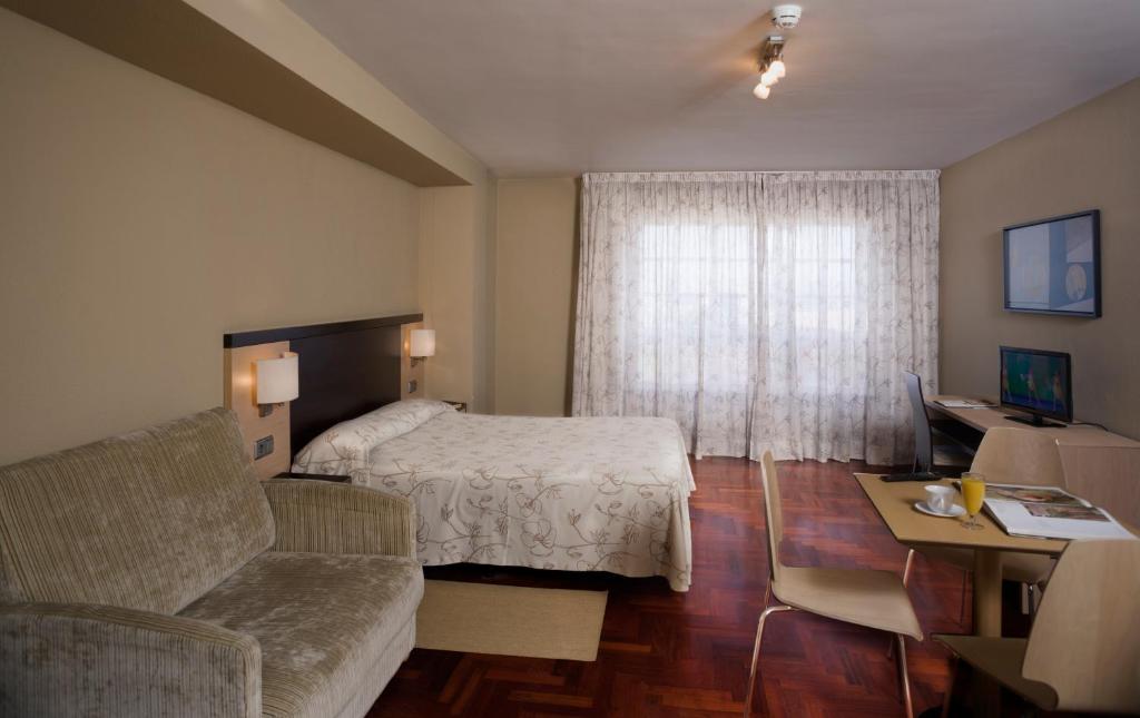 拉科鲁尼亚Apartamentos Portazgo的酒店客房,配有床和沙发