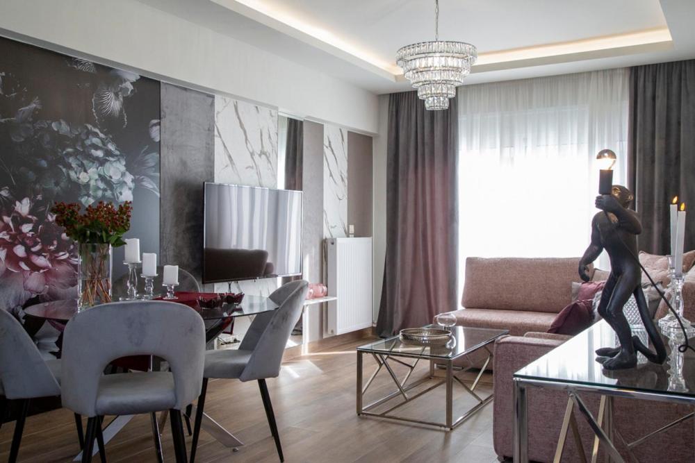 特里卡拉Deka luxury apartment的一间带餐桌的客厅和一间带沙发的客厅