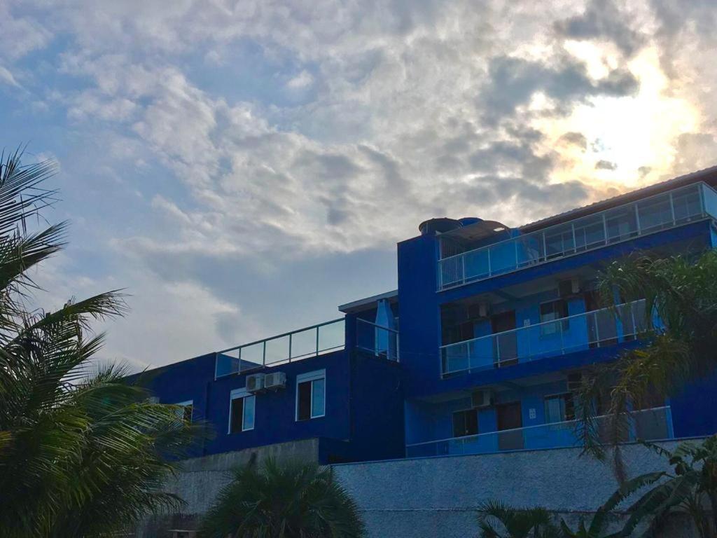 弗洛里亚诺波利斯Residencial Gralha Azul的一座蓝色的建筑,前面有棕榈树