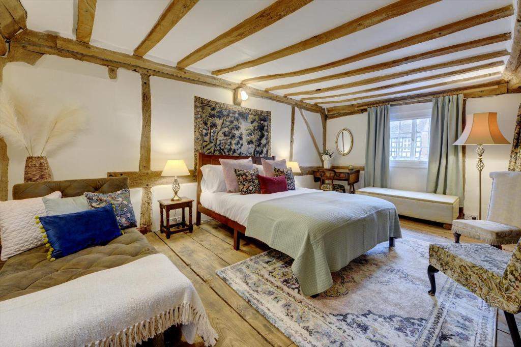 沃里克Tudor Cottage by Spa Town Property - Historic Charm in Warwick Town Centre的大房间设有两张床和一张沙发