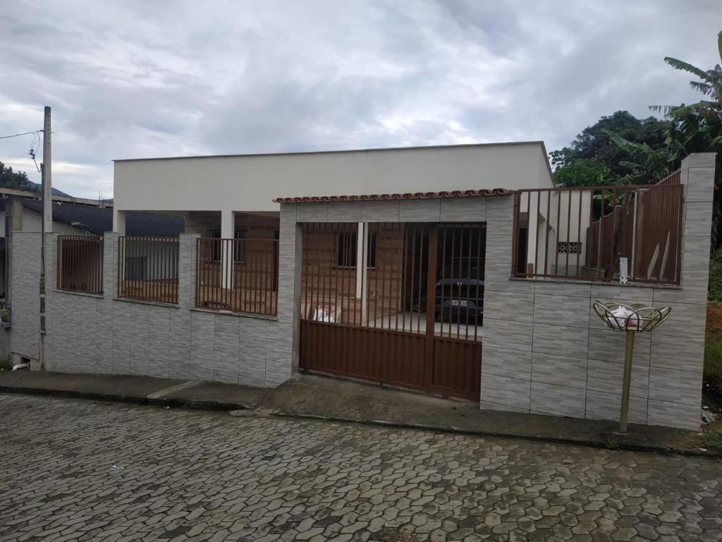 瓜拉派瑞Casa em Guarapari, próximo a praia do morro的一座带围栏和车道的小房子