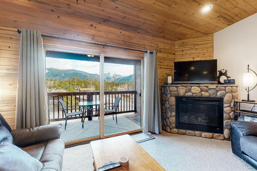 格兰德莱克Bald Mountain Views的带壁炉的客厅,享有甲板的景色