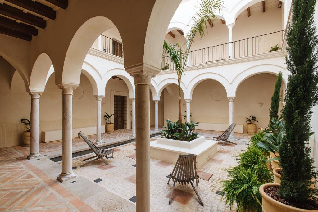 塞维利亚Casa del Rey Sabio的一座室内庭院,在一座建筑中设有喷泉
