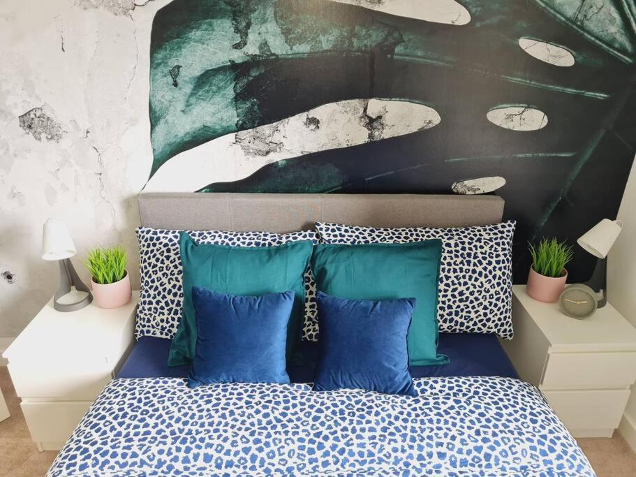 格拉斯哥Stylish 2 bedroom Apartment / FREE Gated Parking的一间卧室配有一张带蓝色和白色枕头的床