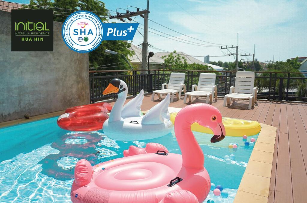 华欣Initial Hua Hin - SHA Plus的两个天鹅在度假村的游泳池里