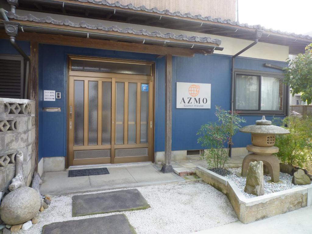 松江市ゲストハウス あずも GuestHouse AZMO的前面有一扇门的蓝色建筑