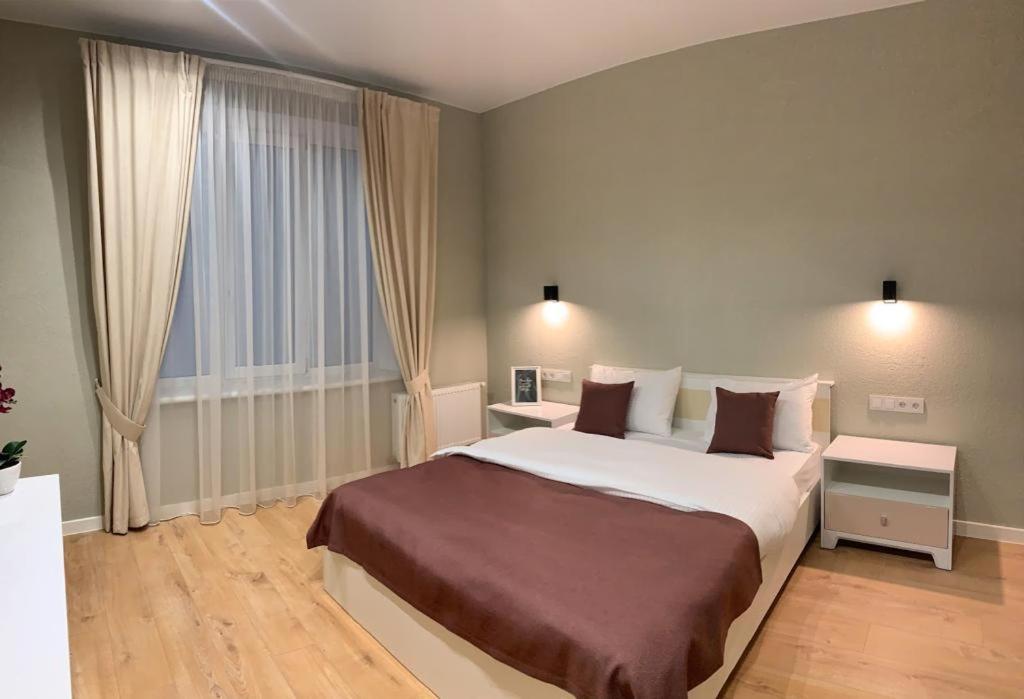尼古拉耶夫Apart City Home的一间卧室设有一张大床和一个大窗户