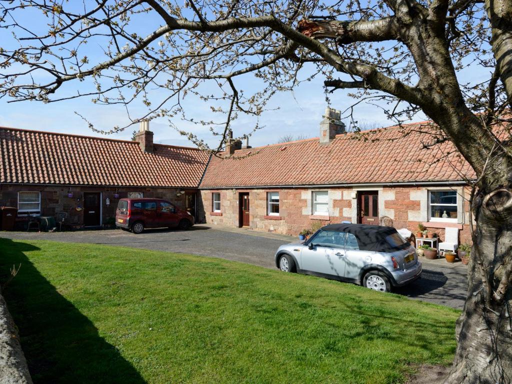 北贝里克Charming Cottage in North Berwick with Sea Views的两辆车停在停车场的房子