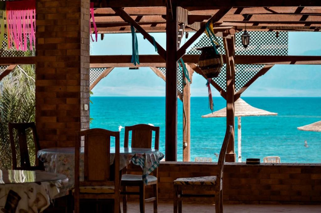 NuweibaElbadawy camp的海景餐厅设有桌椅
