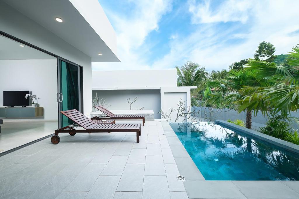 通奈潘海滩T villas的一座带游泳池和两把椅子的房子