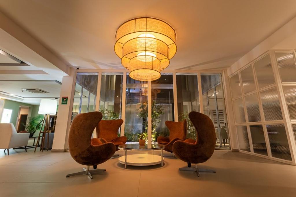 福塔莱萨Ecco Hotel Fortaleza的大堂设有椅子、桌子和吊灯。