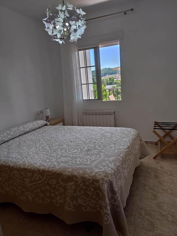 哈兰迪雅·德·拉·维尔Apartamento La Relojera 1的一间卧室配有一张床和一个吊灯