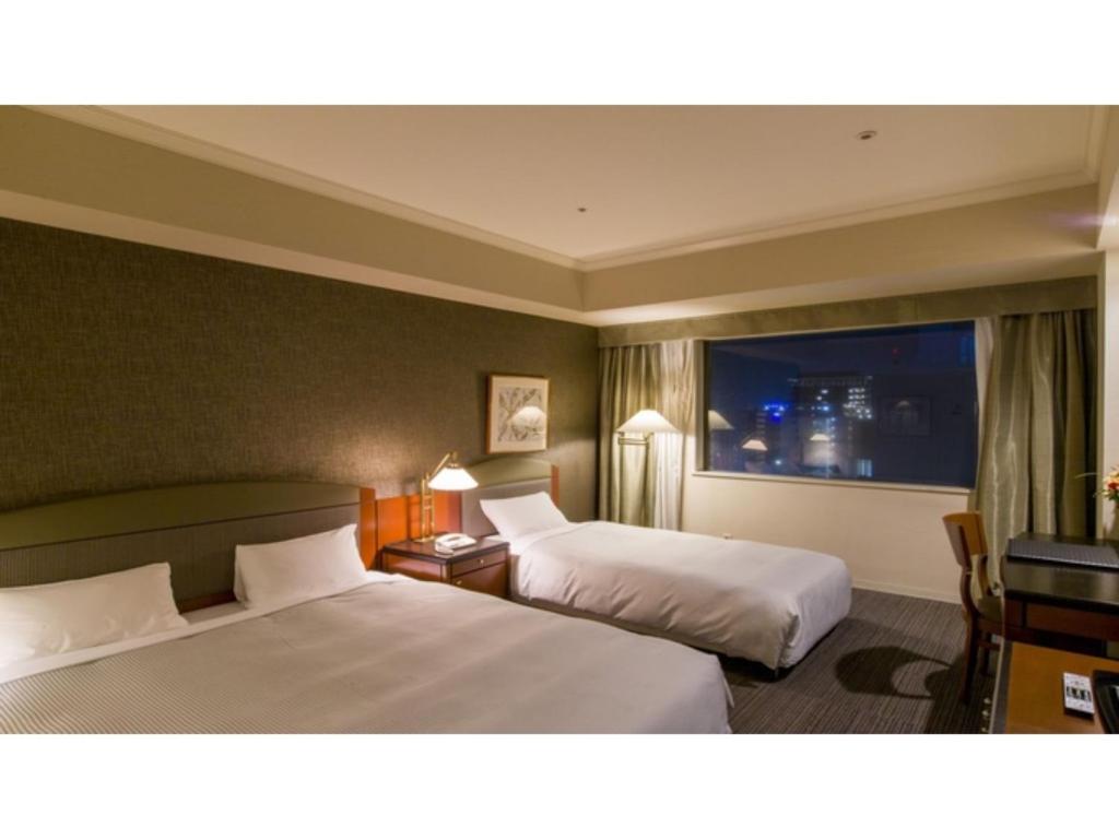 千叶The QUBE Hotel Chiba - Vacation STAY 02243v的酒店客房设有两张床和窗户。