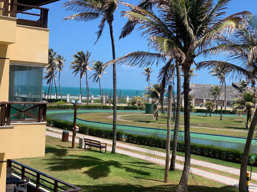 阿奎拉兹Apartamento no Aquaville Resort, do lado da sombra e perto da praia的棕榈树建筑的阳台享有海滩美景。