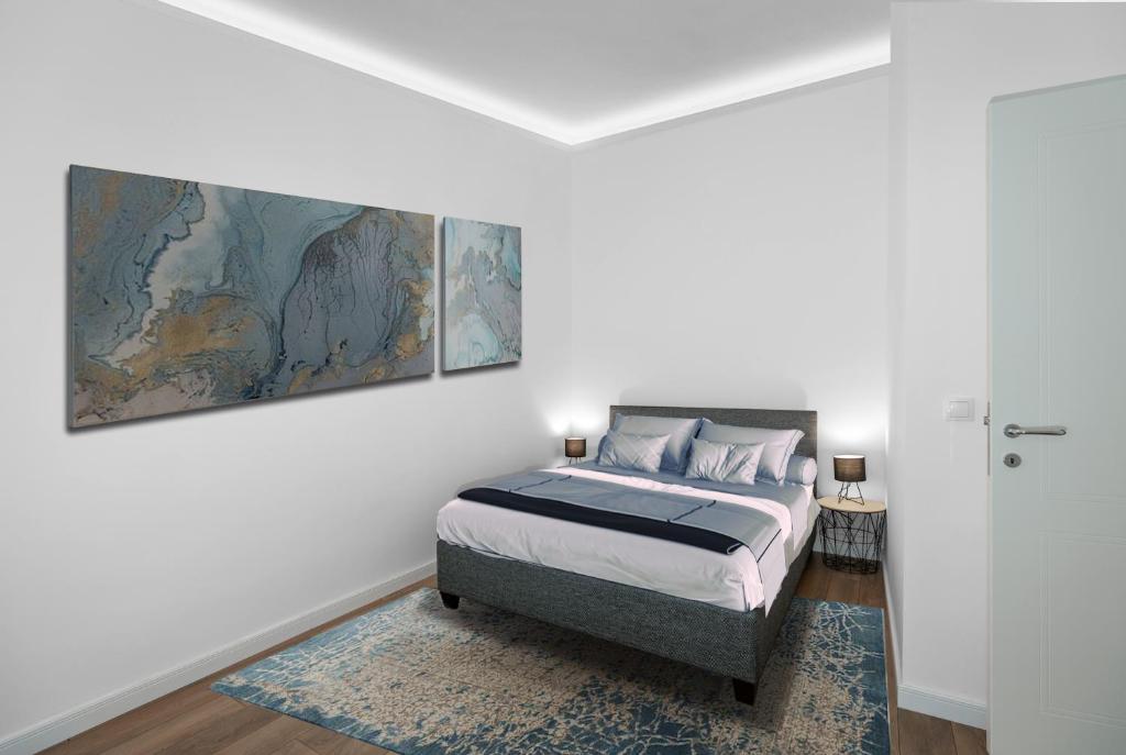 贝尔格莱德Viktor Luxury Suites的卧室配有一张床,墙上挂有绘画作品