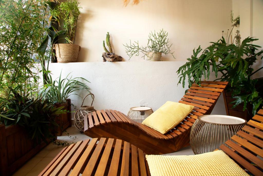 阿基欧斯尼古拉斯Soho #1 Luxurious apartment in Saint Nicolas的庭院设有2个木长椅和盆栽植物