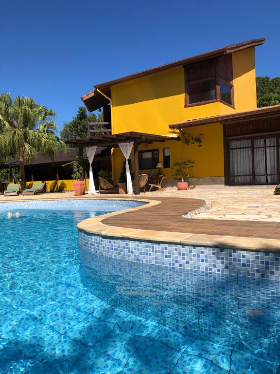 卡纳内亚Jardim Boêmio的房屋前有游泳池的房子
