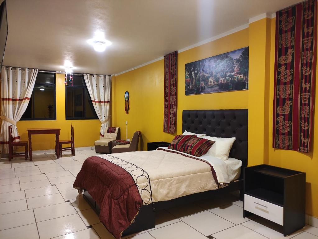 阿亚库乔Casa Sucre Ayacucho的一间卧室设有一张床和黄色的墙壁