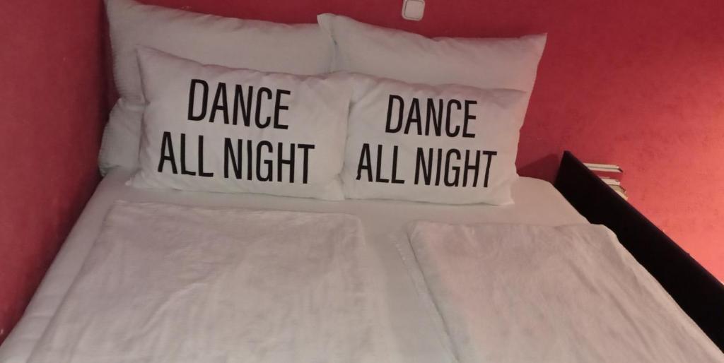 布达佩斯吉泽拉一室公寓酒店的一张带三个枕头的床,整晚都有舞蹈