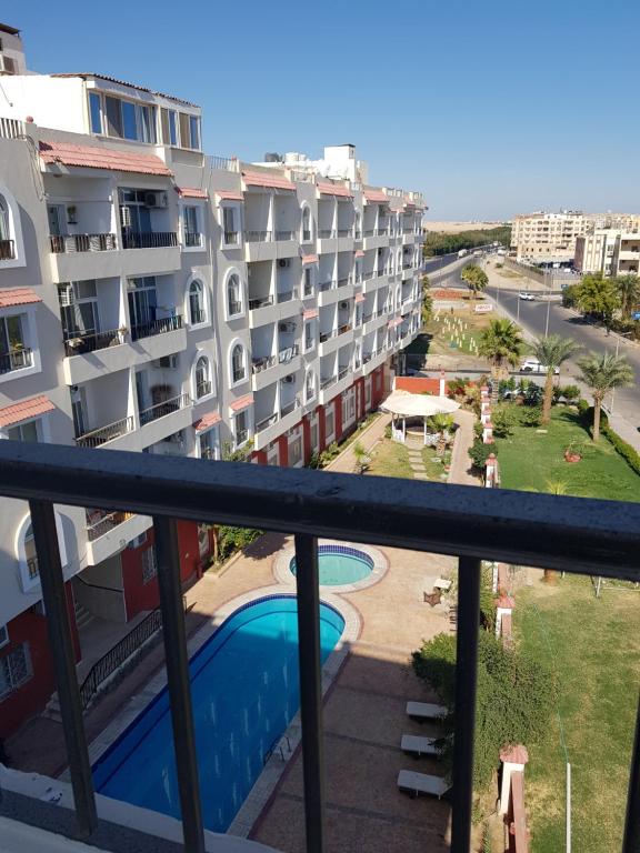 赫尔格达Hurghada Village sea view的从带游泳池的大楼的阳台上可欣赏到风景