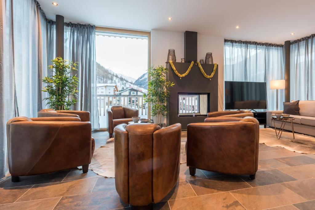 萨斯格伦德Montela Hotel & Resort - Montela Pavillon的客厅设有棕色椅子和壁炉