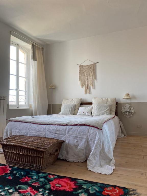 CoursanLe logis blanc bed&breakfast的一间卧室配有一张大床和一个吊灯。