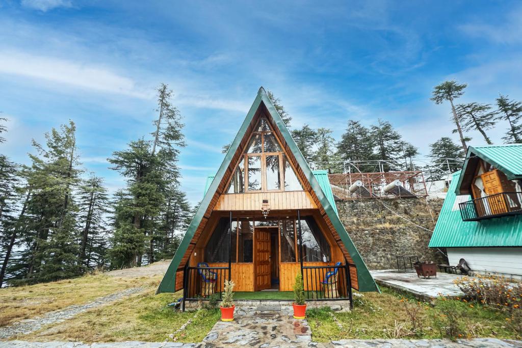 库夫里EKOSTAY - Kufri Chalet的山丘上带绿色屋顶的房子