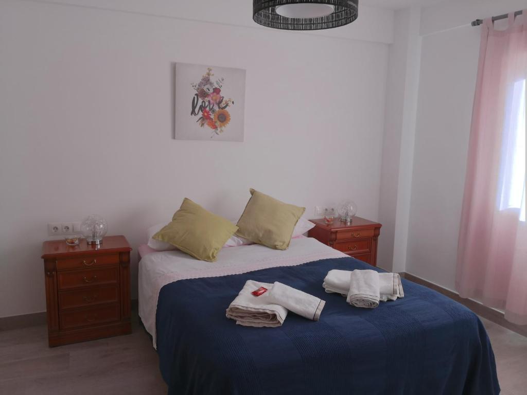 马拉加confortable y luminoso piso 5 camas, parking gratis的一间卧室配有带毛巾的床