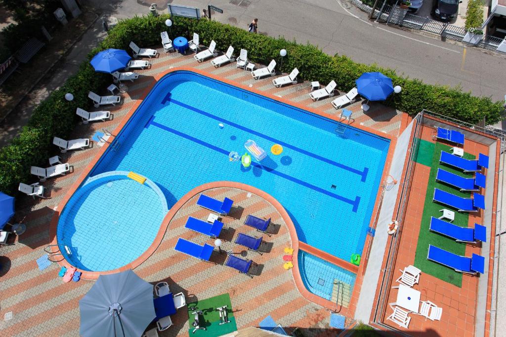 切尔维亚Hotel Real的享有带椅子和遮阳伞的游泳池的上方景色