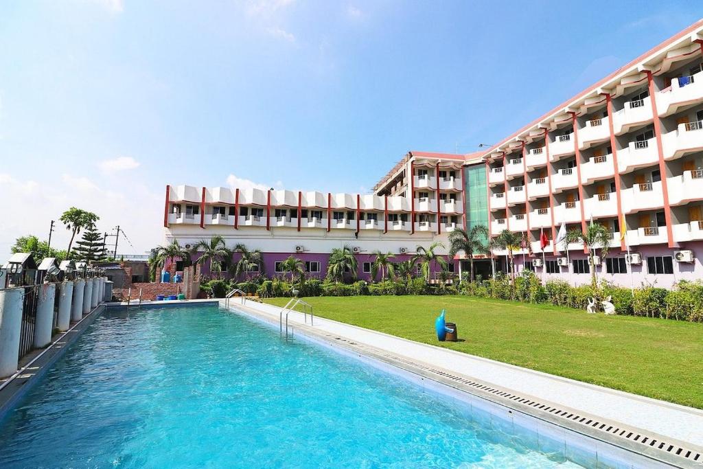 塔拉皮斯MADHU MAMATA HOTEL的大楼前设有游泳池的酒店