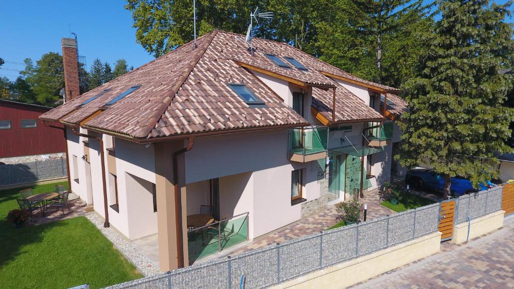 鲍洛通费尼韦什Fenyves Apartmanok的房屋设有瓷砖屋顶和围栏