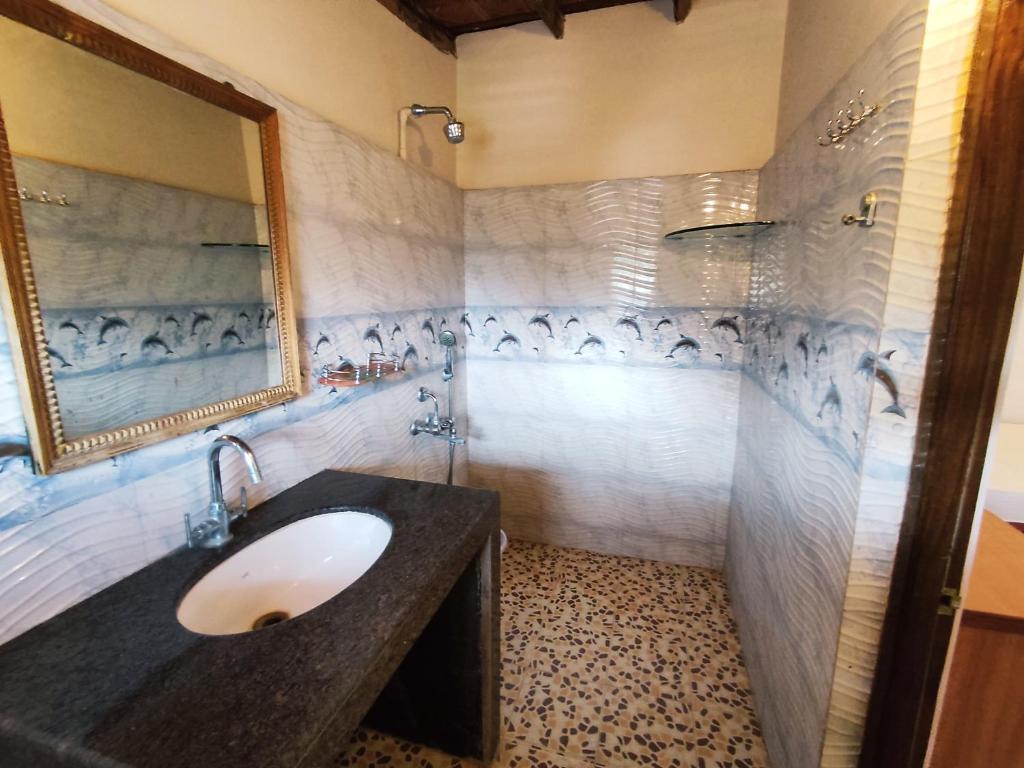 阿贡达Maria Paulo Guest House Bar and Restaurant的一间带水槽和镜子的浴室