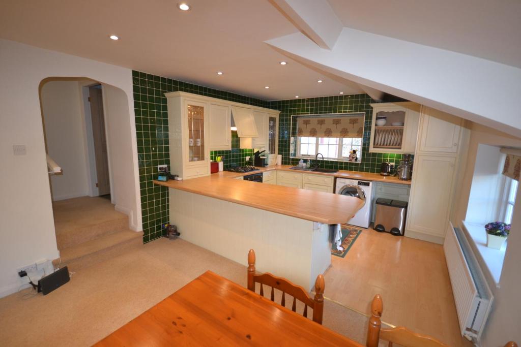 彭里斯Eagle Cottage的厨房设有绿色瓷砖墙壁和台面