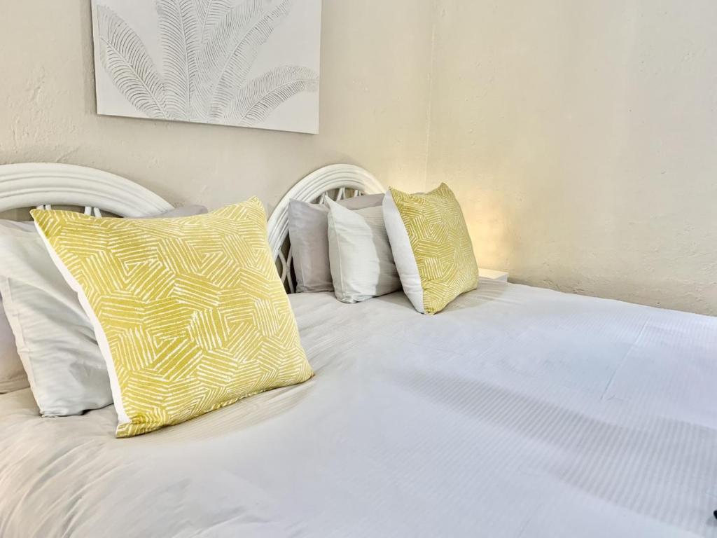 马格巴斯科鲁夫Rondebossie Farm Retreat的白色的床,配有黄色和白色枕头